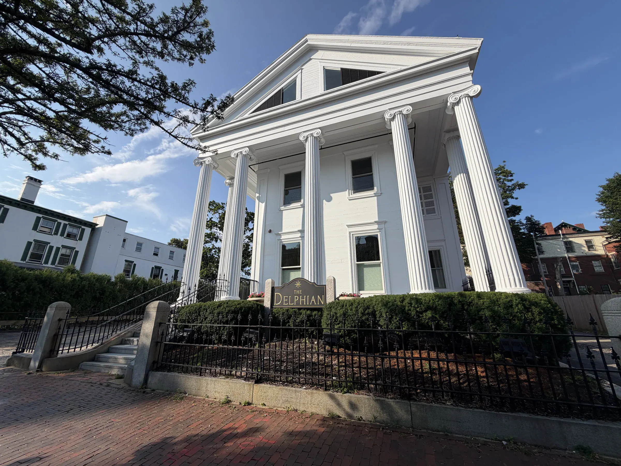 The Delphian's white neoclassical facade, columned portico, and sign on State Street