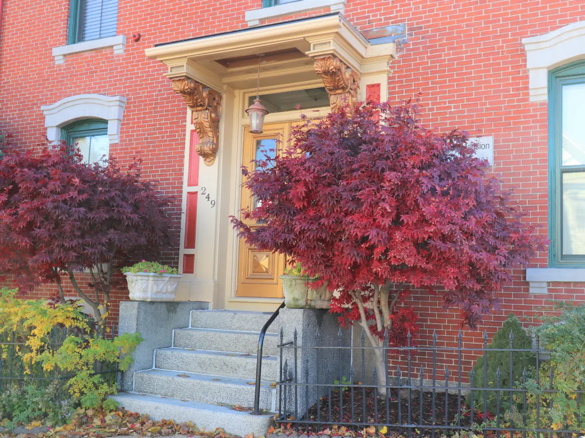 The historic front entrance of The Morrill Mansion in autumn
